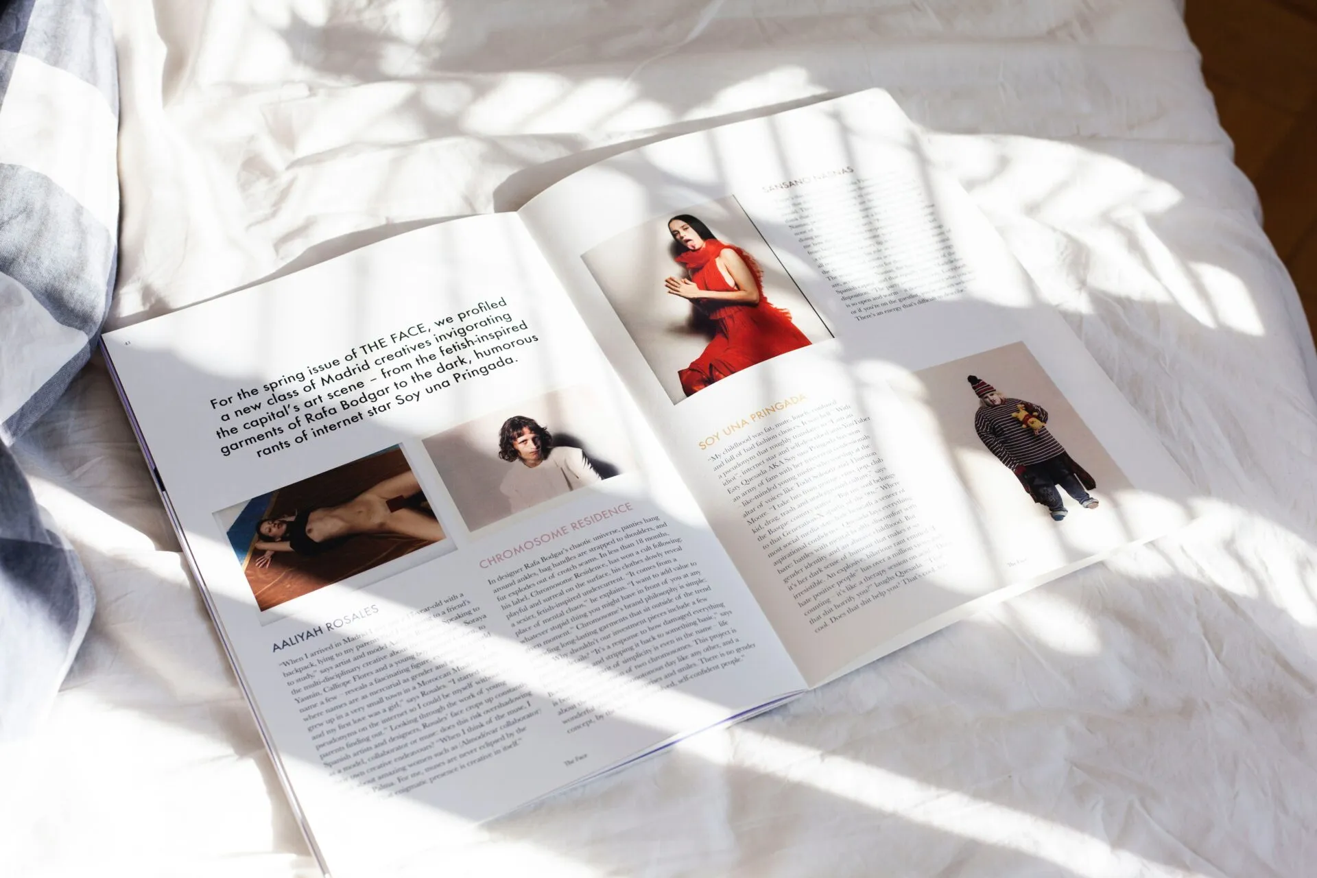Aufgeschlagene Zeitschrift mit Modefotografie auf einer hellen Decke